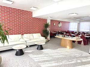 a living room with a couch and tables and a dining room at Hotel Ilomantsi North Star in Ilomantsi