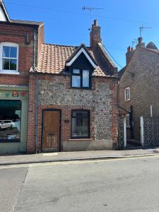 a brick house on the side of a street at Mundesley Cosy cottage in Mundesley