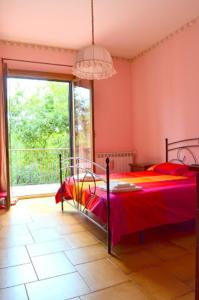 1 dormitorio con cama y ventana grande en B&B Le Tre Rose Di Maria, en Pedara