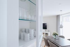 a dining room with white walls and a table and chairs at Anker Mal am Hafen in Husum