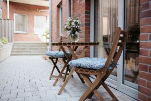 ein Holztisch mit zwei Stühlen und einer Blumenvase in der Unterkunft Anker Mal Husum Stadt in Husum