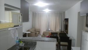 a kitchen and a living room with a counter top at Apart Resort Villa das Águas in Praia do Saco