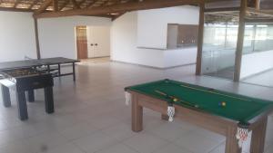 une chambre avec un billard et deux tables dans l'établissement Apart Resort Villa das Águas, à Praia do Saco