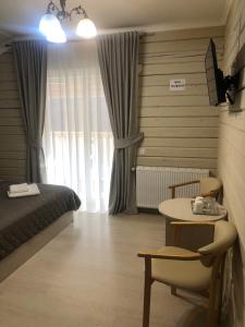 ein Schlafzimmer mit einem Bett, einem Tisch und einem Schreibtisch in der Unterkunft Pogar White in Slawske