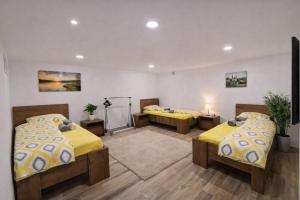 a room with two beds with yellow comforters at DINLUX Apartment in Maribor