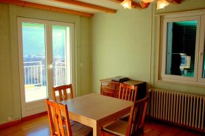 ein Esszimmer mit einem Tisch und Stühlen sowie einem Balkon in der Unterkunft Big Villa in Sainte-croix in Sainte-Croix VD