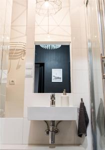 een badkamer met een wastafel en een spiegel bij Marszałkowska Apartament 138 in Warschau