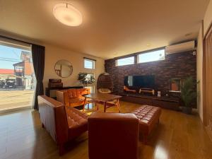 a living room with a couch and a television at 函館 FabulousHouse 一棟貸し最大17名 in Hakodate