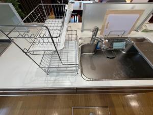 a kitchen sink with a dish drying rack on it at 函館 FabulousHouse 一棟貸し最大17名 in Hakodate +80 photos