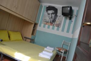 a room with a bed and a tv on a wall at Miramare struttura sulla spiaggia in Platamona