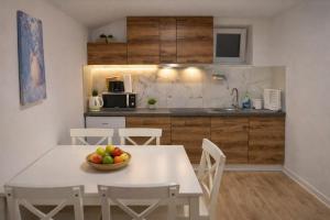 a kitchen with a table with a bowl of fruit on it at DINLUX Apartment in Maribor