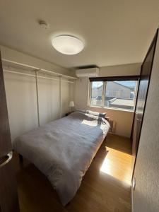 a bed in a room with a large window at 函館 FabulousHouse 一棟貸し最大17名 in Hakodate