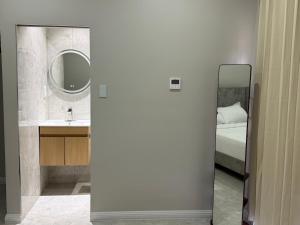 a bathroom with a mirror and a bed and a sink at Sanrai in Gros Islet