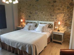 a bedroom with a large bed with two tables and two lamps at El Rincón de Escalante in Escalante