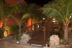 a wooden staircase in a building with palm trees at Pousada Gaivotas do Guaraú in Peruíbe