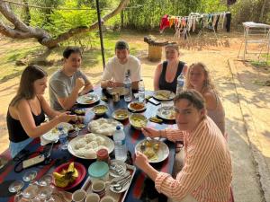 a group of people sitting around a table with food at Dambulla City Hostel in Dambulla