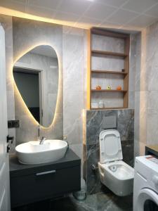 a bathroom with a sink and a toilet and a mirror at Ankara Esenboğa Airport Comfort Apart in Ankara +71 photos
