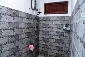a brick shower with a pink animal on the wall at Ella River Breeze Homestay in Ella