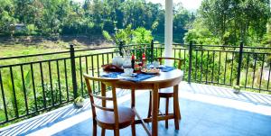 a table and chairs on a balcony with a view at Ella River Breeze Homestay in Ella
