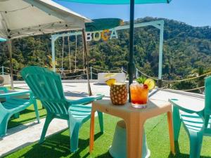 ein Tisch mit Stühlen und ein Tisch mit einem Getränk darauf in der Unterkunft Vista Boca in Puerto Vallarta