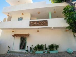 ein Schild an der Seite eines Gebäudes mit Pflanzen in der Unterkunft Vista Boca in Puerto Vallarta + 2 Fotos