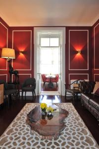 a living room with red walls and a glass table at Fonte Da Foz in Figueira da Foz