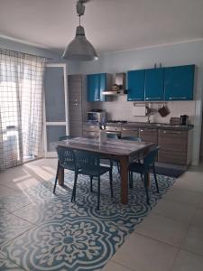 a kitchen with a table and chairs and blue cabinets at Macari Residence Central Apartment in Macari +52 photos