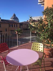 een paarse tafel en 2 stoelen op een patio bij La Terrazza Sui Miracoli in Pisa