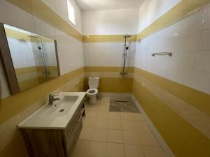 a bathroom with a sink and a toilet at Aghir DJERBA Erdgeschosswohnung in Al Ḩaddādah