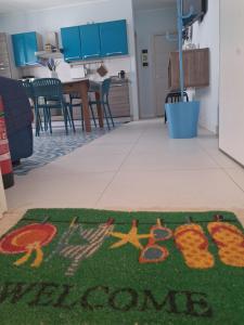 a welcome rug on the floor of a kitchen at Macari Residence Central Apartment in Macari