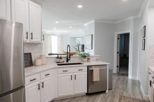 a kitchen with white cabinets and a sink at Modern Condo Near Wright-Patt Shops & Dining in Beavercreek