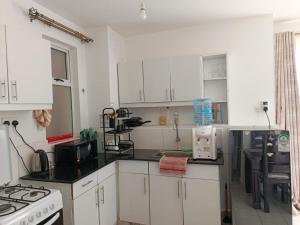 a kitchen with white cabinets and black counter tops at Nyumbani in Nairobi