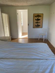 a bedroom with a bed and a chair in it at Ellemose Bed and Breakfast in Lemvig