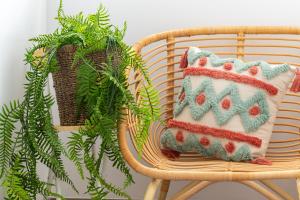 a pillow sitting on a chair next to a plant at Xi Mu in Taitung City