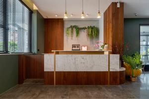 a lobby with a reception desk with plants on the wall at Xi Mu in Taitung City