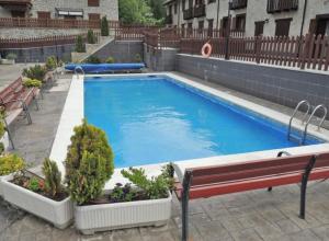 een groot zwembad met een bank en een aantal planten bij Torres de Vallibierna 7 in Anciles