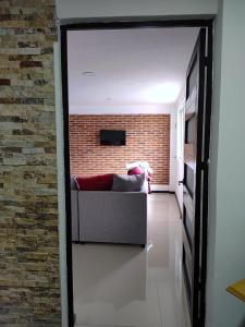a living room with a couch and a brick wall at Hospedaje La Patrona in Chignahuapan