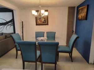 a dining room with a table and blue chairs at Hospedaje La Patrona in Chignahuapan