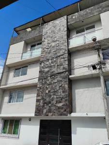 an apartment building with a stone wall at Hospedaje La Patrona in Chignahuapan
