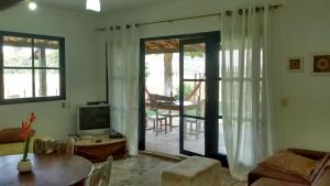 a living room with a sliding glass door to a patio at Pousada Camping Porto Grande in Meaípe