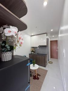 a kitchen with a vase of flowers on top of a refrigerator at Rochomes Apartment in Thịnh Châu