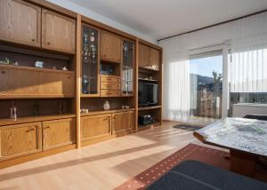 a living room with wooden cabinets and a large window at Apartment Am Kleehagen 26, Winterberg-Niedersfeld in Winterberg