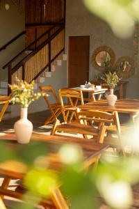 a group of tables and chairs with flowers in vases at Pousada Unaí - Casa Flor in Fernando de Noronha