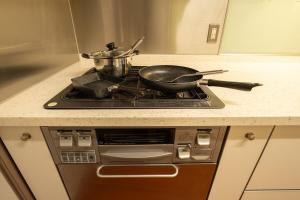 a frying pan on top of a stove in a kitchen at HP Jōshin in Nagoya
