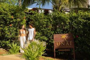 a man and a woman standing next to a sign at Pousada Unaí - Casa Flor in Fernando de Noronha