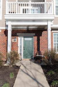 a brick building with a green door and a balcony at Modern Condo Near Wright-Patt Shops & Dining in Beavercreek