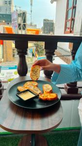 a person holding a plate of food on a table at Hostel Prada in Lima