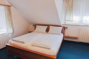 a bedroom with a wooden bed with two pillows at Hotel Stangl in Hamm