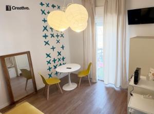 a living room with a table and chairs and a mirror at Hotel Nizza Creative Hotel in Rimini +77 photos