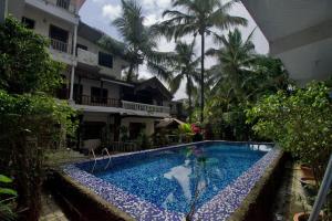 a swimming pool in front of a building at Da Down Resort & Hotel in Candolim +35 photos